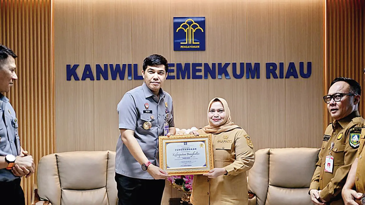 TERIMA PENGHARGAAN: Bupati Bengkalis Hj Kasmarni menerima penghargaan pengelolaan JDIHN terbaik kedua dari Kepala Kantor Wilayah Kementerian Hukum Provinsi Riau Rudy Hendra Pakpahan di Kantor Kemenhum Perwakilan Riau di Pekanbaru, Senin (6/7/2026).(Pemkab bengkalis untuk riau pos)