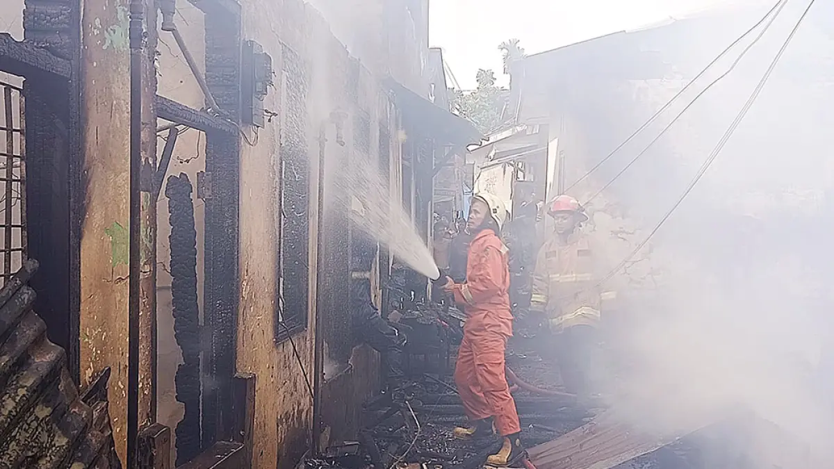 PADAMKAN API: Petugas melakukan upaya pemadaman api yang membakar rumah warga di Jalan H Agus Salim, Gang Beecek, Kelurahan Sukaramai, Kecamatan Pekanbaru Kota, Kamis (9/7/2026). (Damkar kota Pekanbaru untuk riau pos)