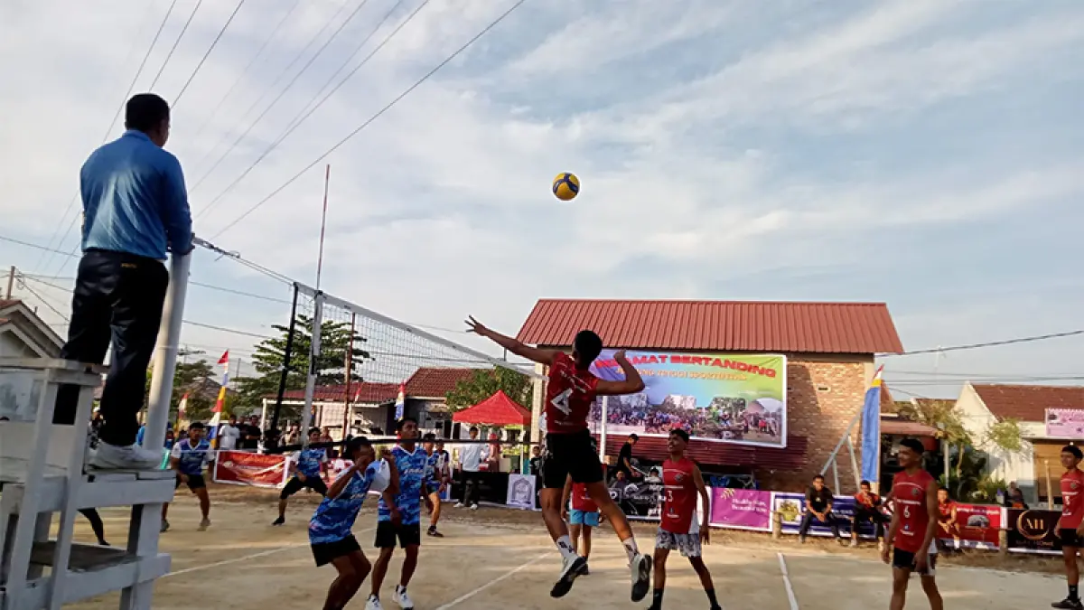 Tim PRB memberikan bola smes kepada tim GMI dalam pertandingan pembuka Turnamen Bola Voli Putra Tingkat Kecamatan Tambang, Kabupaten Kampar di Lapangan Graha Mutiara Indah, Sabtu (11/7/2026). (Muslim nurdin/riaupos.co)