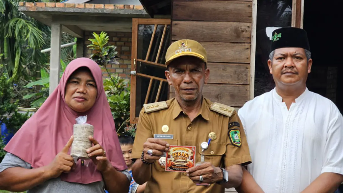 Suryati pelaku usaha terasi bersama Kepala Desa Ketapang Permai, Safrizal, dan Camat Pulau Merbau, Hermansyah, serta sejumlah pihak terkait. (Wira Saputra/Riaupos.co)