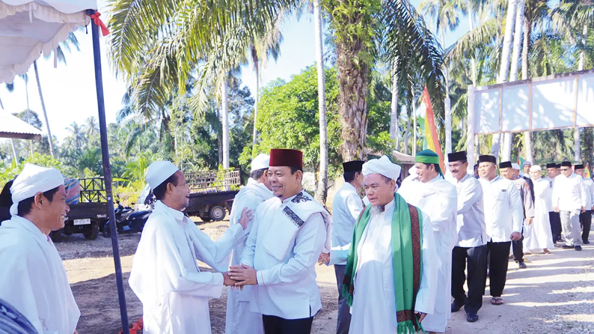 DISAMBUT: Wabup Rohul H Syafaruddin Poti beserta rombongan disambut oleh tuan guru, mursyid dan jemaah Tareqat&nbsp;Naqsabandiyah saat menghadiri Haul ke-66 Syekh Muhammad Noer Rokan di Madrasah Suluk Serambi Muara Musu, Kecamatan Rambah Hilir, Kamis (9/7/2026). (Prokopim Setda Rohul untuk Riau Pos)