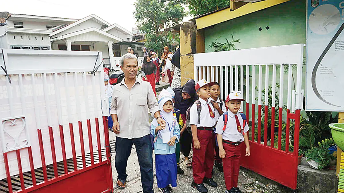 ANTAR KE SEKOLAH: Seorang wali murid mengantarkan anaknya ke sekolah di SDN 165 Jalan Serasi Pekanbaru, Senin (13 /7/2026). (EVAN GUNANZAR/RIAU POS)
