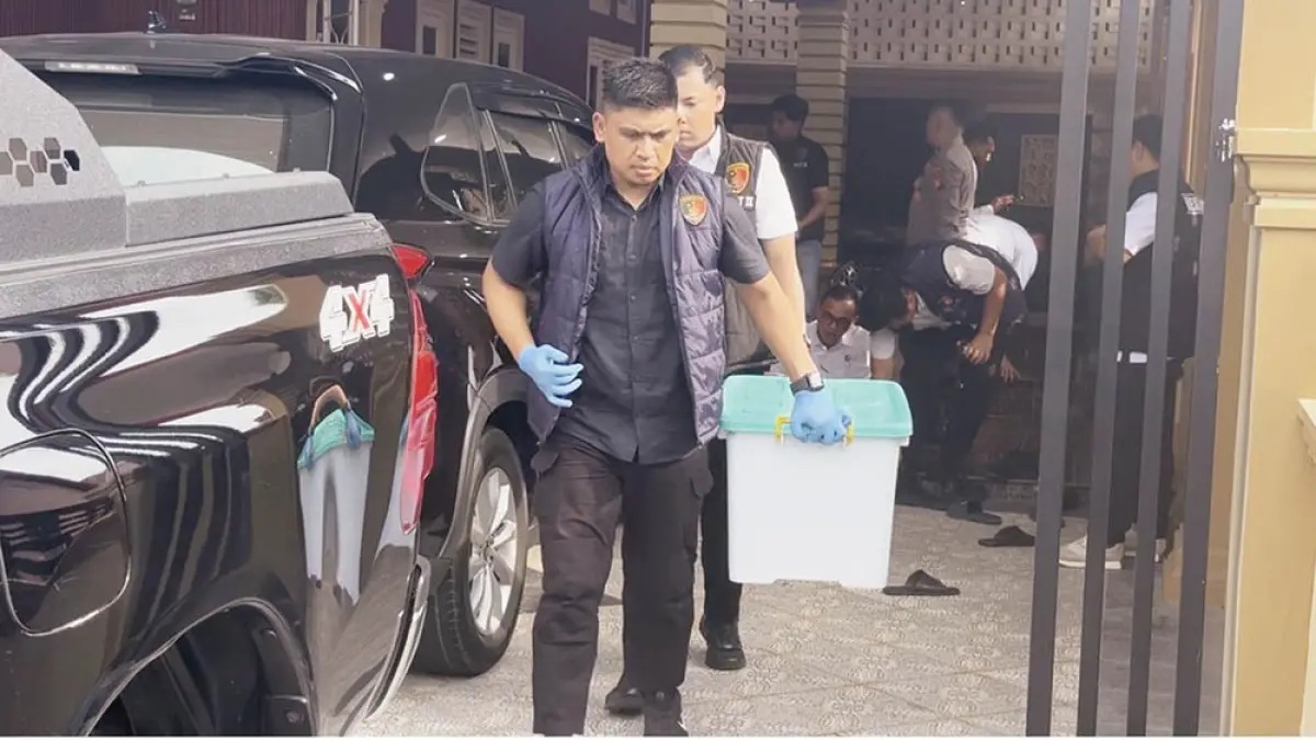 Tim Tipidkor Satuan Reskrim Polres Siak membawa kontainer berisi barang bukti usai penggeledahan di kediaman Kadishub Siak nonaktif Junaidi Jalan Sutomo, Kelurahan Kampung Dalam, Siak Sriindrapura, Senin (13/7/2026). (polres siak untuk riau pos)