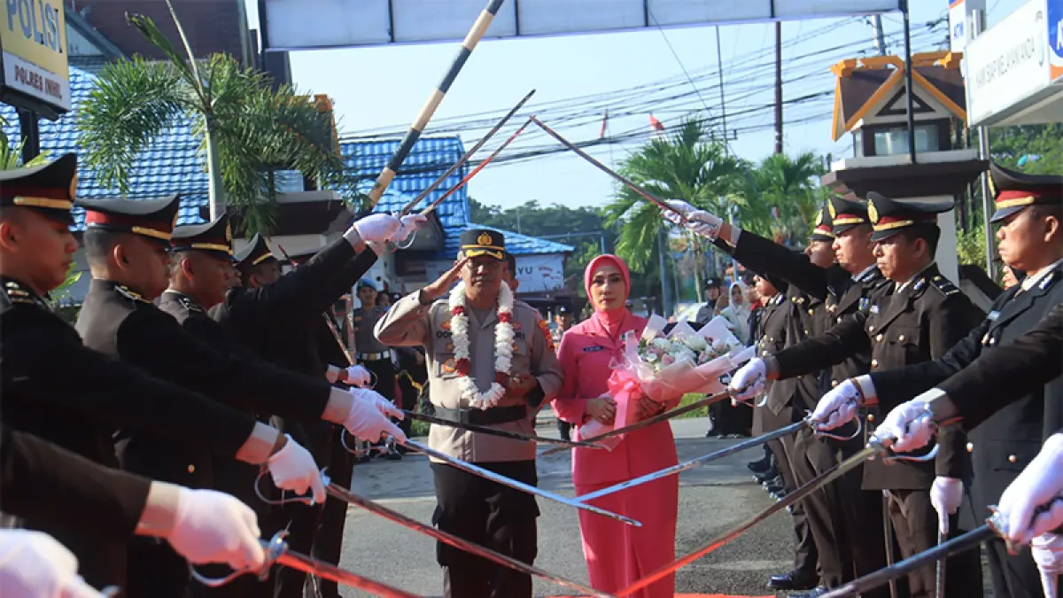 AKBP Donny Eko Listianto SH SIK MH bersama Ketua Bhayangkari Cabang Inhil melintasi tradisi Pedang Pora saat prosesi Welcome and Farewell Parade di Mapolres Inhil, Rabu (15/7/2026).(Istimewa)
