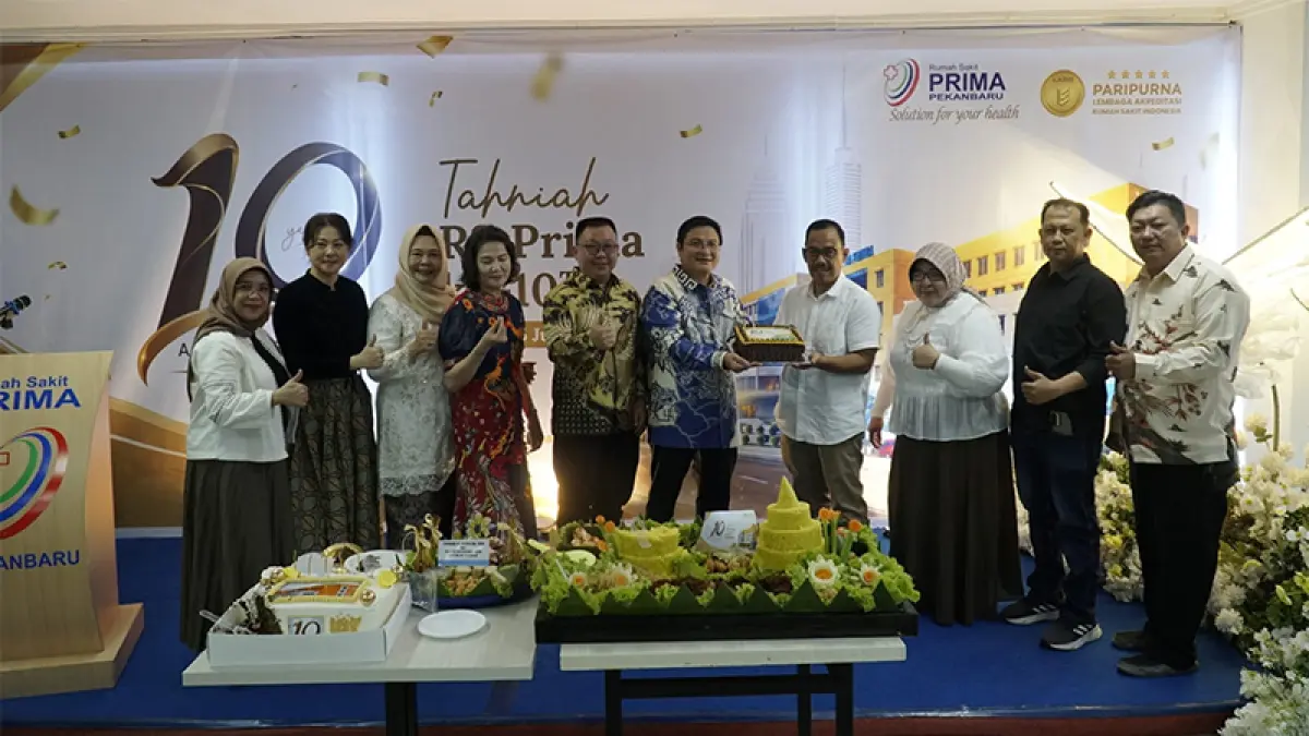 Direktur Riau Pos Asmawi Ibrahim serahkan kue tar 10 tahun RS Prima di Pekanbaru, Rabu (15/7). ( MHD AKHWAN/RIAUPOS.CO)