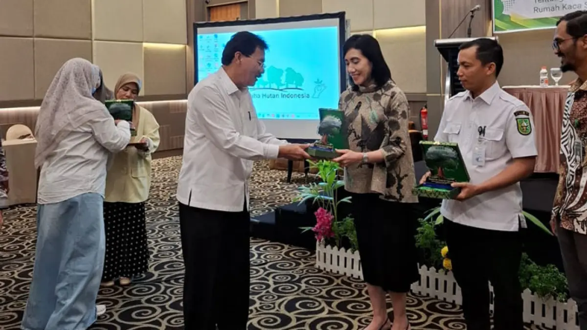 Ketua APHI Riau Muller Tampubolon menyerahkan cendramata kepada para pembicara Diskusi Perdagangan Karbon di salah satu hotel di Pekanbaru pada Rabu (15/7/2026). (APHI Riau untuk Riaupos.co)