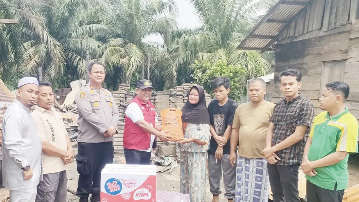 SERAHKAN BANTUAN: Camat Kepenuhan Gustia Hendri menyerahkan bantuan Pemkab Rohul kepada korban yang rumahnya terbakar di Desa Ulak Patian, Sabtu (18/7/2026). (Dinas Kominfo Rohul untuk Riau Pos)