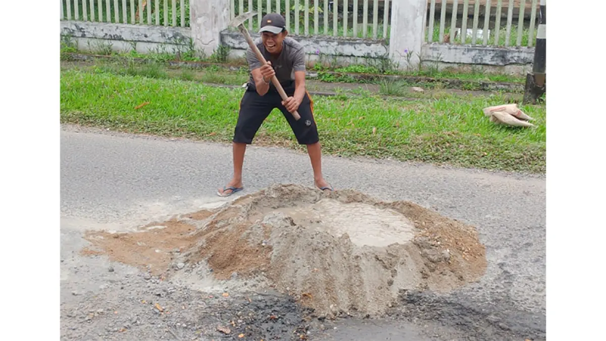 Warga bergotong-royong menambal lubang di Jalan Baharudin Yusuf, tepatnya di depan Masjid YAMP, Kelurahan Sungai Beringin, Kecamatan Tembilahan, Selasa (21/7/2026).(Istimewa)