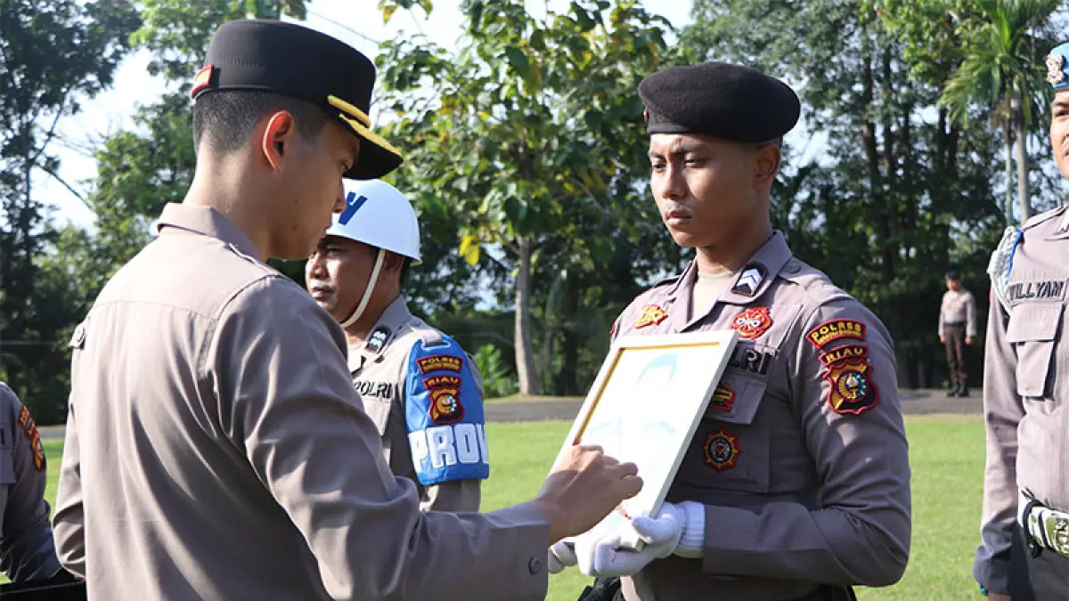 Kapolres Kuansing AKBP Hidayat Perdana SH SIK MH memberikan tanda silang pada foto personel yang di copot, dalam upacara Rabu (22/7/2026) di halaman Mapolres Kuansing. (Istimewa)
