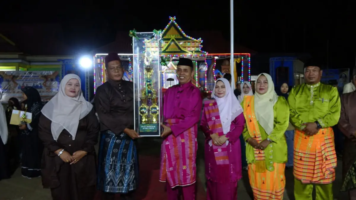 Bupati Inhil Herman menyerahkan piala bergilir kepada pemenang lomba di MTQ Kecamatan Pulau Burung, Rabu (22/7/2026). (Diskominfo Inhil)
