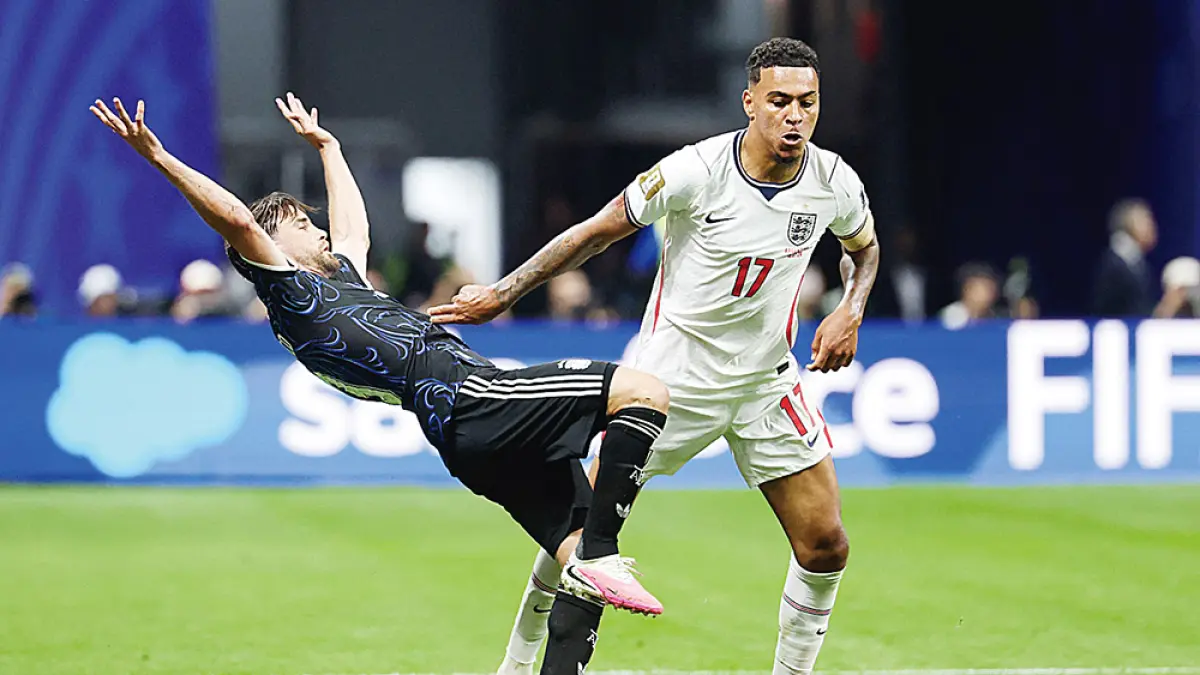 Gelandang Inggris Morgan Rogers (kanan) berebut  bola dengan bek Argentina  Nicolas Tagliafico dalam pertandingan semifinal sepakbola Piala Dunia 2026, baru-baru ini. (Odd ANDERSEN/AFP)
