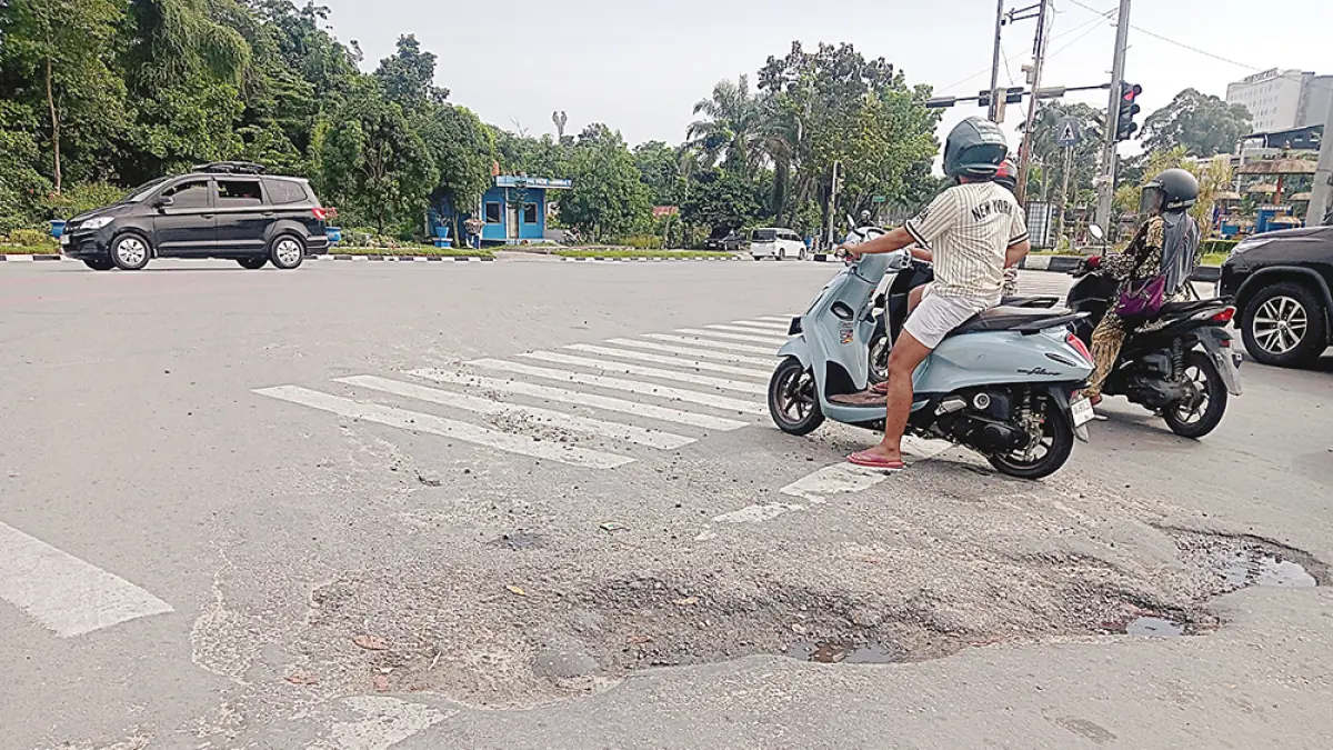 LUBANG: Kondisi ruas Jalan Kaharuddin Nasution tepatnya di persimpangan bandara  berlubang dan rusak, Rabu (22/7/2026).&nbsp;(Prapti Dwi Lestari/riau pos)
