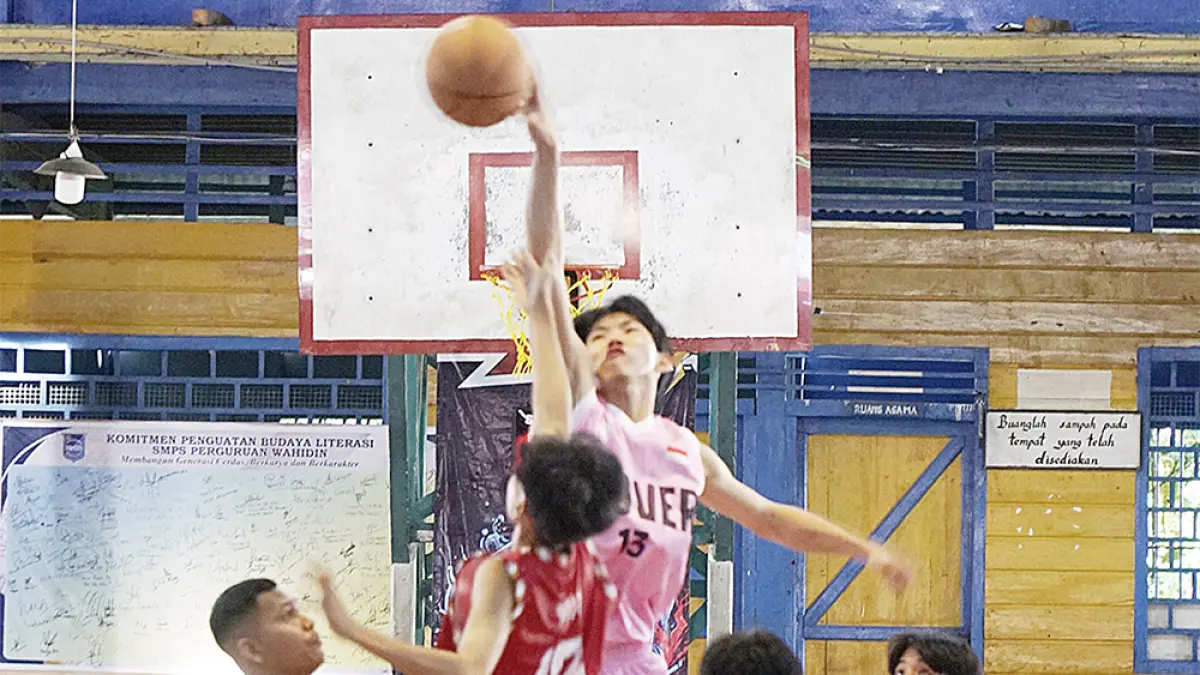 Pemain basket putra SMA Wahidin (pink) be­­rebut bola saat melawan SMA Methodist (merah) dalam per­tandingan perdana Riau Pos-HSBL 2026 Bagansiapiapi Se­ries  di  lapangan Perguruan Wahidin, Rabu (22/7/2026). (MHD AKHWAN/RIAU POS)
