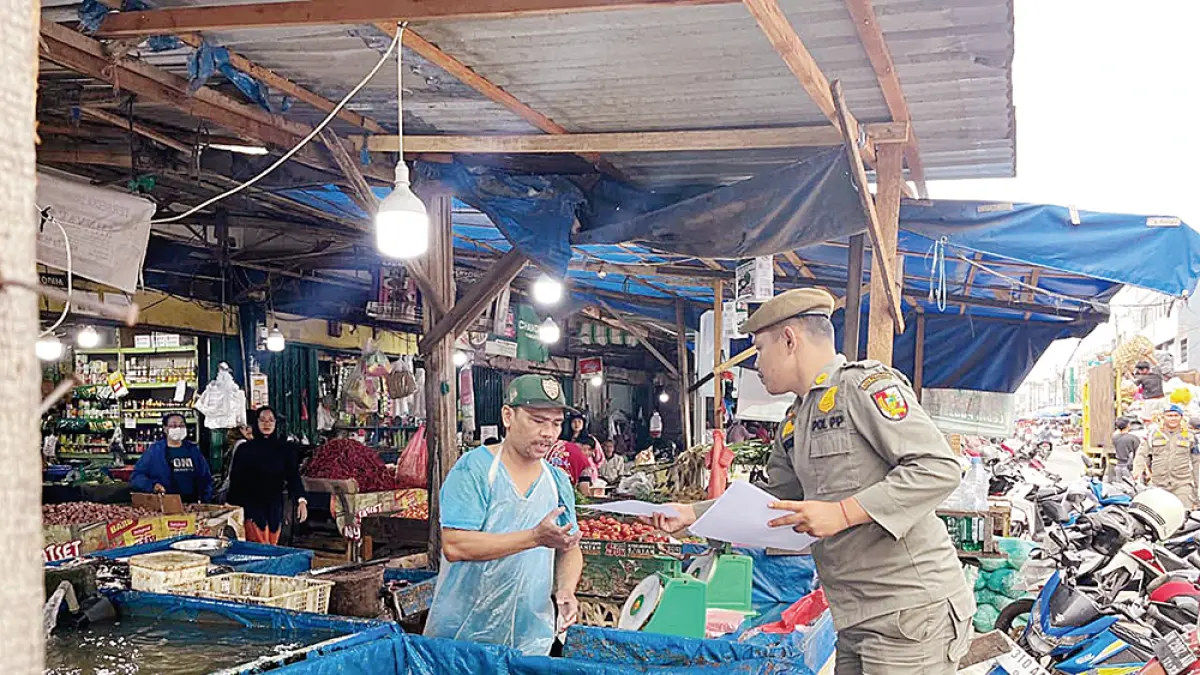 BERIKAN SURAT: Petugas Satpol PP Pekanbaru memberikan surat pembongkaran lapak kepada pedagang yang berjualan di Jalan Teratai Ujung, Kamis (23/7/2026). (Prapti Dwi Lestari/riau pos)