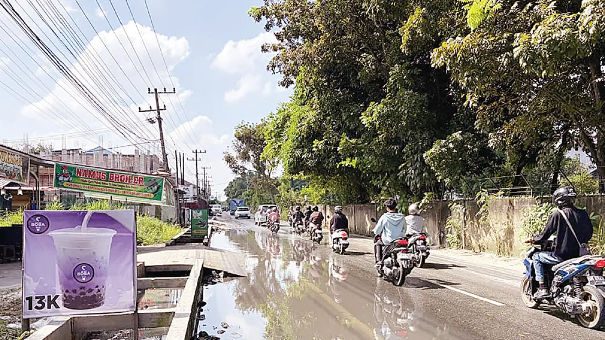 TERGENANG: Genangan air di Jalan Bangau Sakti membuat pengendara harus menurunkan kecepatan saat melintas, Kamis (23/7/2026).&nbsp;(Prapti Dwi Lestari/riau pos)
