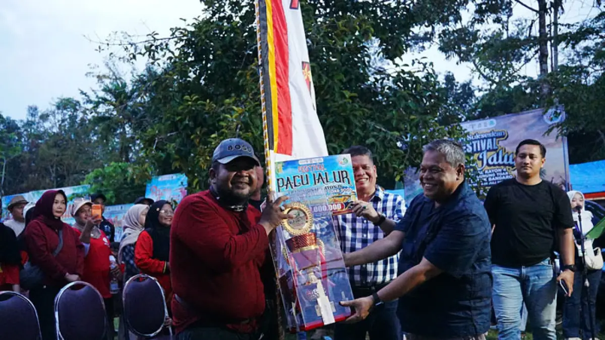 Plh Sekda Kuansing Drs Muradi MSi bersama Asisten II Drs Napisman menyerahkan piala Juara I pada Halmadi Asmara perwakilan Jalur Keramat Jubah Merah, saat penutupan pacu jalur rayon IV Gunung Toar, Ahad (26/7/2026) petang. (Istimewa)