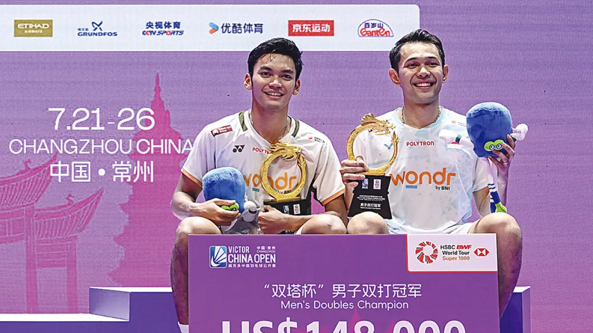 Ganda putra Indonesia Fajar Alfian (kanan) dan Muhammad Shohibul Fikri, berpose di podium saat upacara penyerahan penghargaan setelah mengalahkan pasangan Korea Selatan, Kim Won-ho dan Seo Seung-jae, dalam final ganda putra turnamen bulutangkis China Open di Changzhou, Ahad (26/7/2026).  (AFP)