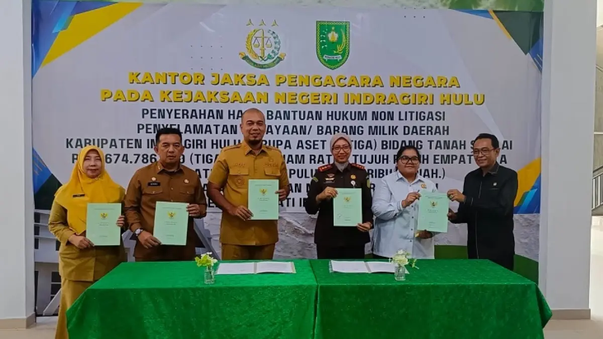 Bupati Inhu, Ade Agus Hartanto dan Kajari Inhu, Dr Ratih Andrawina Suminar SH MH bersama pejabat lainnya melihatkan berita acara penyerahan aset tanah yang diselesaikan secara non litigasi, Senin (27/7/2026). (Raja Kasmedi/Riaupos.co)