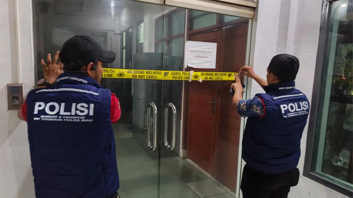 Petugas dari Subdit III Ditreskrimsus Polda Riau saat memasang police line di Kantor Dinas PUTR Rokan Hilir, Selasa (28/7/2026). (Istimewa)