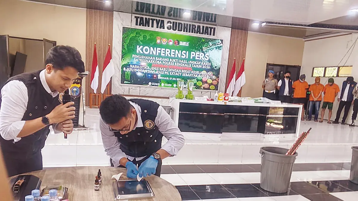 TES Barang Bukti: Petugas Labfor Polda Riau mengetes keaslian barang bukti sabu dan pil ekstasi sebelum dilakukan pemusnahan di aula Mapolres Bengkalis, Senin (27/6/2026). (abu kasim/riau pos)
