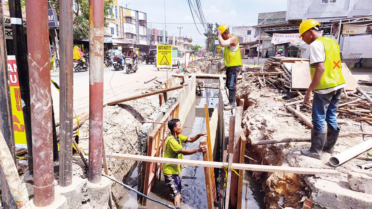 PERBAIKAN DRAINASE: Pekerja melakukan pengerjaan perbaikan drainase di Jalan Dharma Bakti, Kecamatan Payung Sekaki, belum lama ini. (EVAN GUNANZAR/RIAU POS)
