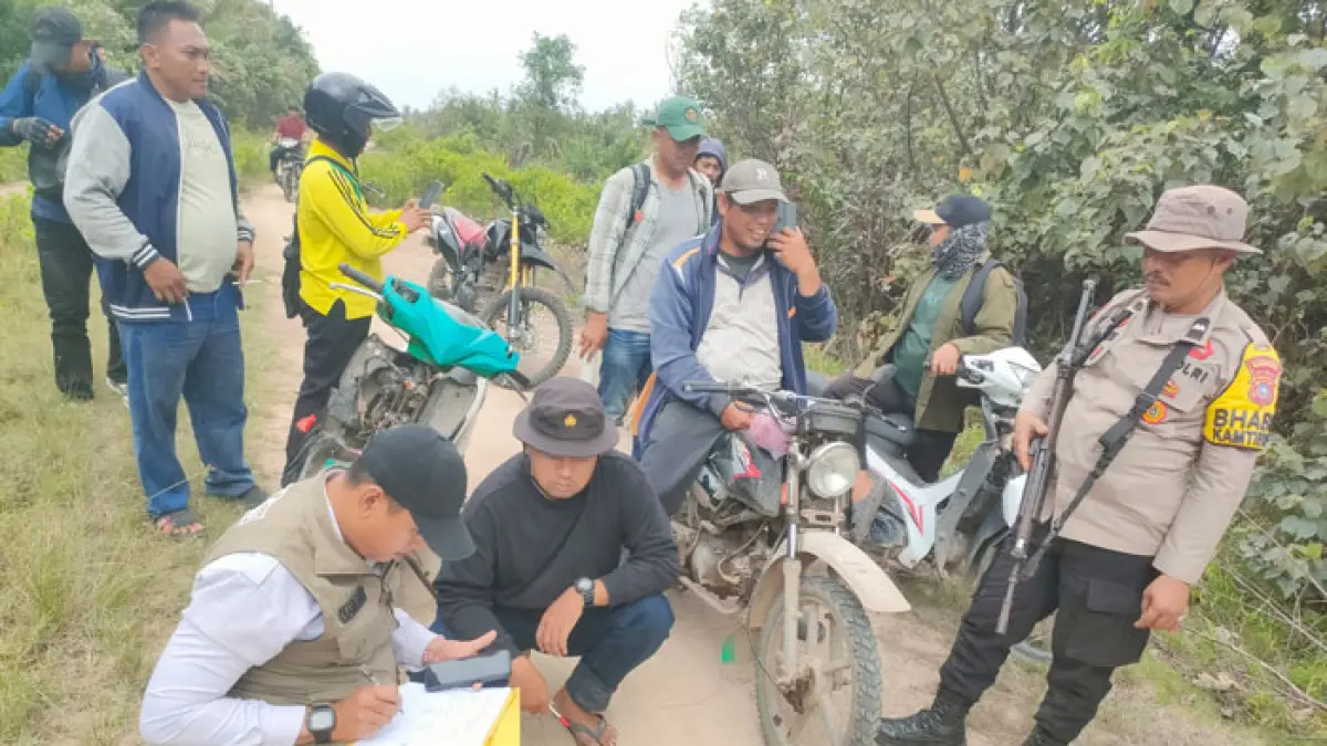 Sebelum memasang camera trap, Personel Polsek Pulau Burung bersama BBKSDA Riau mengecek jejak kaki harimau di Desa Sungai Danai, Kecamatan Pulau Burung, Kabupaten Inhil, Selasa (28/7/2026). (Istimewa)