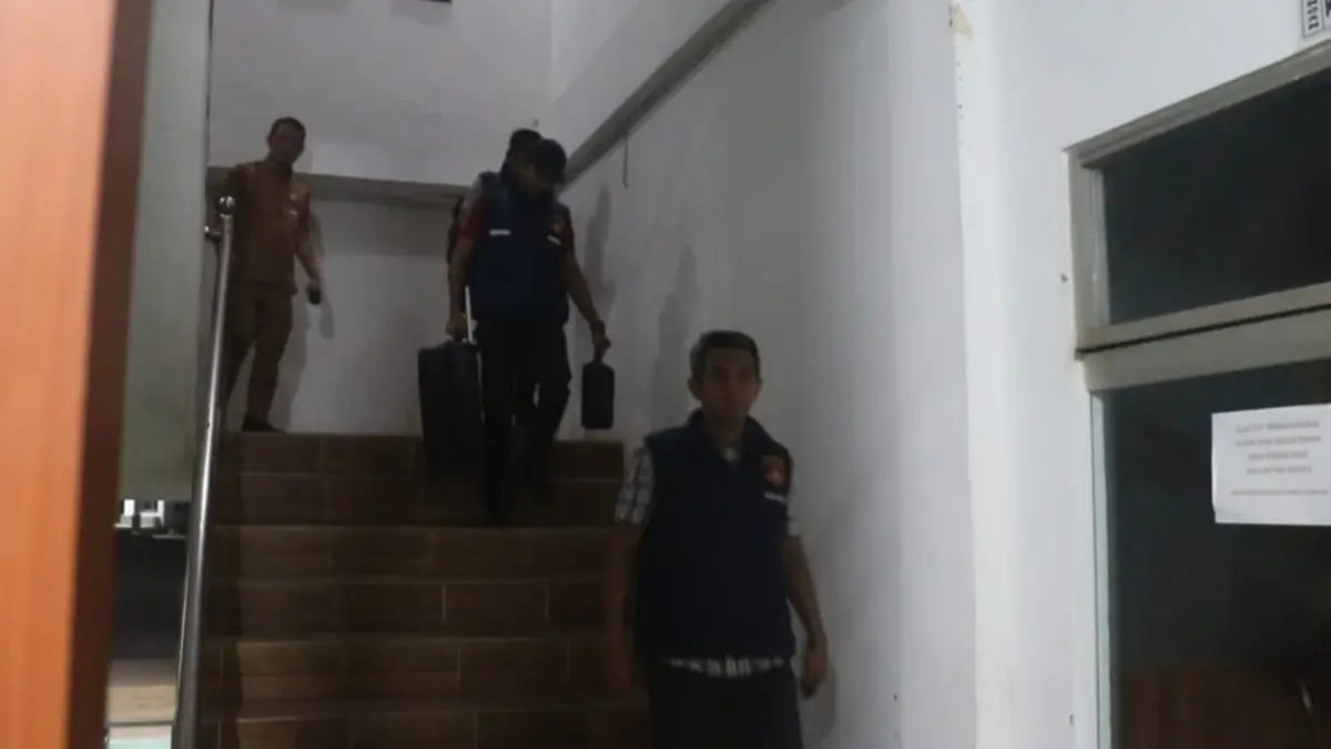 Tim Subdit 3 Tipidkor saat meninggalkan ruangan pengeledahan dari lantai dua, kantor dinas PUTR Rohil, Selasa (28/7/2026) malam. (Zulfadhli/Riaupos.co)