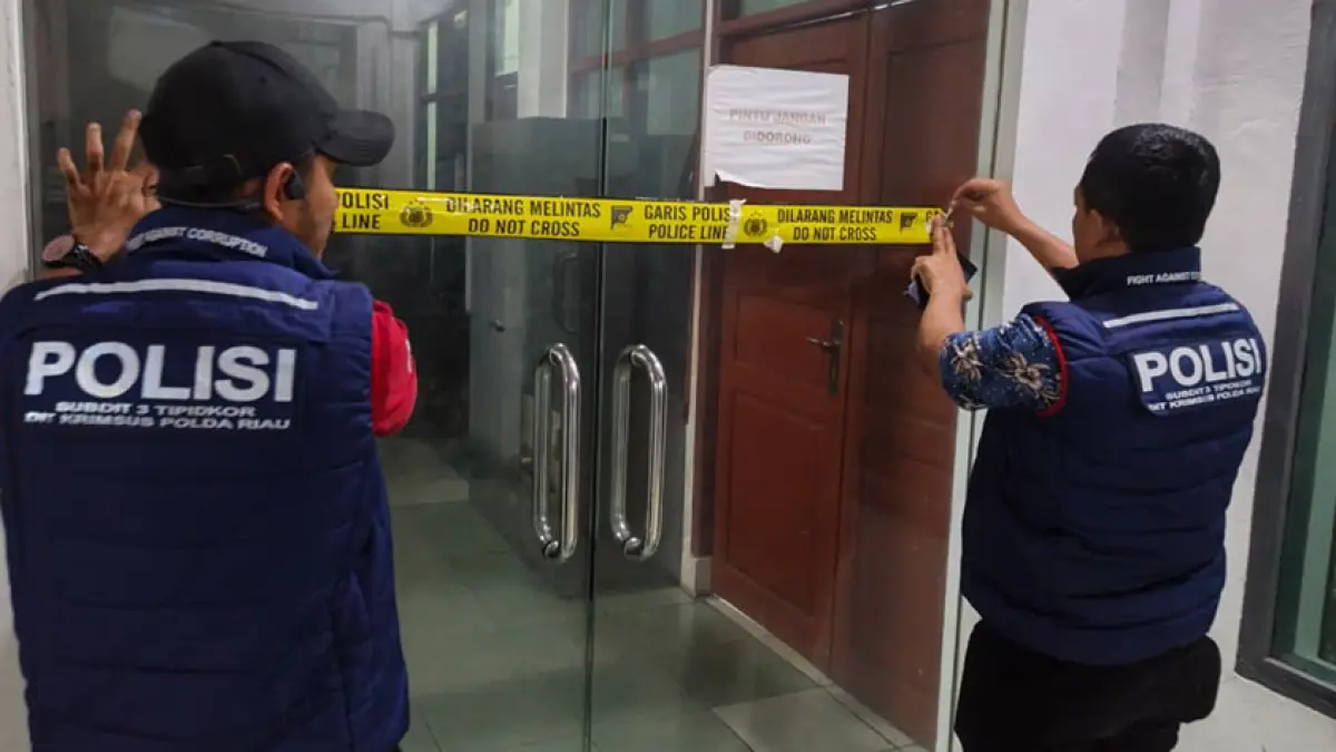 Tim Subdit III Tindak Pidana Korupsi Direktorat Reserse Kriminal Khusus Polda Riau memasang garis polisi di salah satu pintu Kantor Dinas Pekerjaan Umum dan Tata Ruang Rokan Hilir yang digeledah, Selasa (28/7/2026). (POLDA RIAU UNTUK RIAU POS)