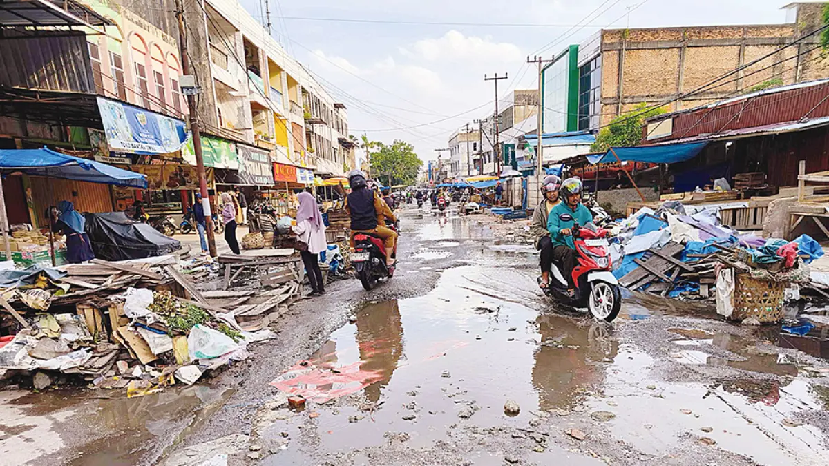 JALAN RUSAK: Kondisi Jalan Teratai yang rusak dan kiri-kanan jalan terdapat lapak-lapak pedagang, Selasa (28/7/2026). (EVAN GUNANZAR/RIAU POS)