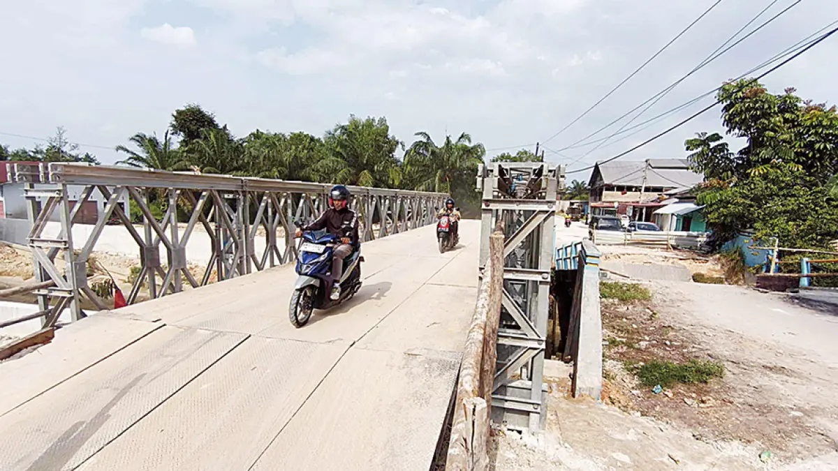 JEMBATAN BAILEY: Pengendara melintas di atas jembatan bailey yang dipasang di lokasi jembatan ambruk di Jalan Nelayan, Kecamatan Rumbai, Pekanbaru, Rabu (29/7/2026). (EVAN GUNANZAR/RIAU pos)

