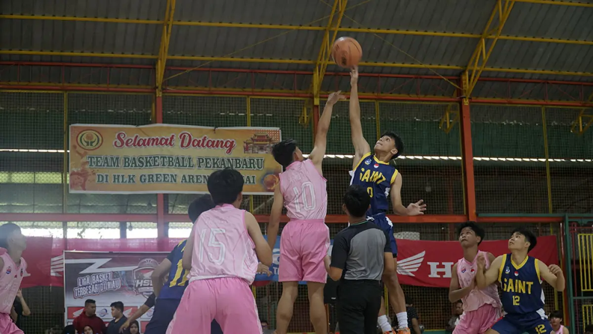 Pemain SMAS Santo Tarcisius  (kanan) dan SMKN1  Dumai berebut bola pada laga pembuka Riau Pos-HSBL 2026 Du­mai Series  di  lapangan HLK Green, Dumai, Rabu (29/7/2026). (MHD AKHWAN/RIAU POS)