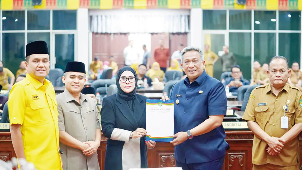 PERLIHATKAN BERITA ACARA: Bupati Rohul Anton bersama Ketua DPRD Rohul Hj Sumiartini memperlihatkan berita acara persetujuan Ranperda Pertanggungjawaban APBD 2025 menjadi Perda dalam rapat paripurna di Gedung DPRD Rohul, Senin (27/7/2026) malam. (JPG)