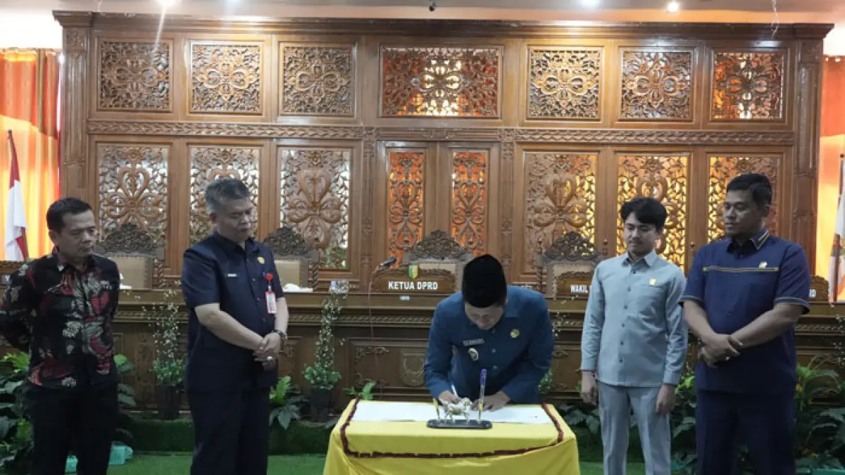 Plt Bupati Kuansing H Muklisin menanda tangani berita acara pengesahan Ranperda LPj pelaksanaan APBD tahun 2025 menjadi Perda dalam Paripurna DPRD, Jumat (31/7/2026) sore. (Desriandi Candra/Riaupos.co)