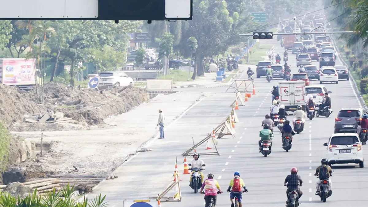 SIMPANG SEBIDANG: Pengerjaan ruas jalan simpang sebidang antara Jalan Jenderal Sudirman-Jalan Arifn Achmad terus dilakukan di tengah kepadatan arus lalu lintas kendaraan, beberapa hari lalu. Pemko Pekanbaru menargetkan pembangunan simpang sebidang ini akan selesai akhir tahun 2026. (MHD AKHWAN/RIAU POS )