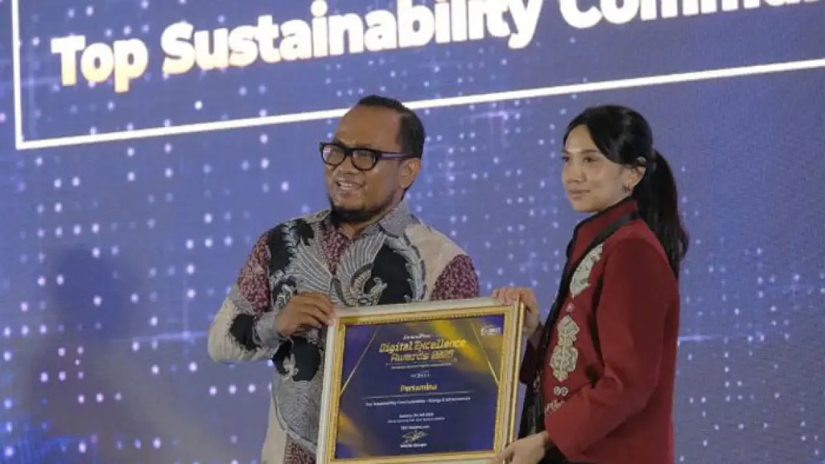 CEO JawaPos.com Dhimas Ginanjar serahkan penghargaan Top Sustainability Communication by Energy & Infrastructure di acara Jawa Pos Digital Excellence Award 2026. kepada Sr. Officer Media Communication PT Pertamina (Persero), Intania Prionggo di Hotel Bidakara, Jakarta Selatan, Kamis (30/7). (Istimewa) 