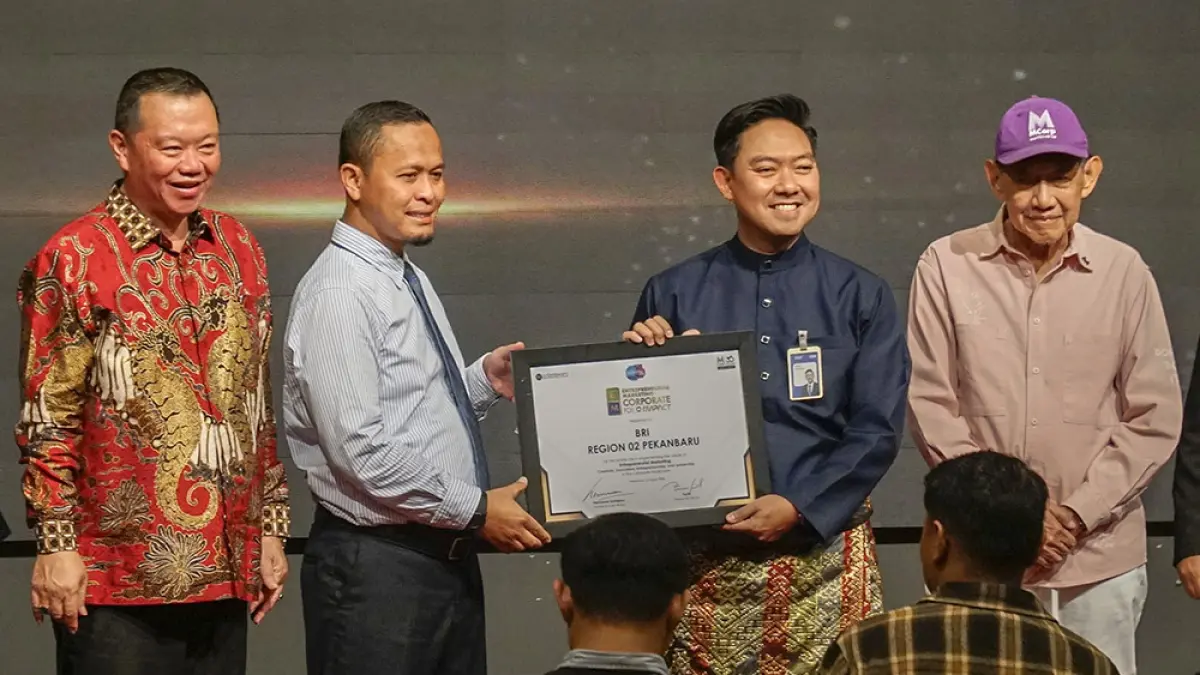 Regional Wholesale Banking Head BRI Region 2 Pekanbaru Rizky Ferdian menerima Entrepreneurial Marketing Corporate For Impact 2026 Riau untuk BRI Region 2 Pekanbaru yang diserahkan langsung oleh Wali Kota Pekanbaru Agung Nugroho didampingi Founder & Chair of MCorp Markpluscorp & Marketeers Hermawan Kartajaya (kanan) dan Peng Suyoto (kiri) di Hotel Premiere, Pekanbaru, Kamis (6/8/2026). (MHD AKHWAN/RIAUPOS)