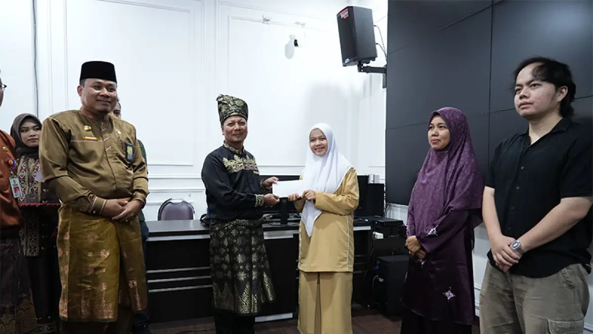 Plt Bupati Kuansing H Muklisin didampingi Kakan Kemenag H Suhelmon MA menyerahkan bonus pada peserta terbaik 1 Kuansing Cabang Hifzil Quran 1 Juz Tilawah. (Istimewa)
