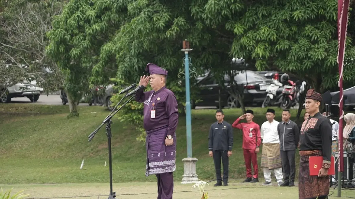 Pj Sekda Kuansing Drs Muradi MSi Memimpin upacara HUT Riau ke 69 Tahun, Ahad (9/8/2026) di lapangan Komplek Pemkab Kuansing. (Istimewa)