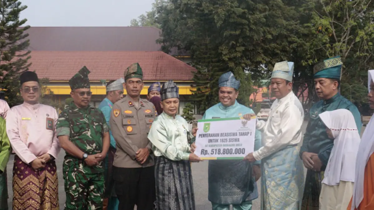 Ketua Baznas Kabupaten Inhu, Sri Guntur saat menyerahkan secara simbolis beasiswa untuk 1.625 orang kepada Wabup Inhu, Ir H Hendrizal MSI, Senin (108/2026). (Diskominfotik Inhu untuk Riaupos.co)