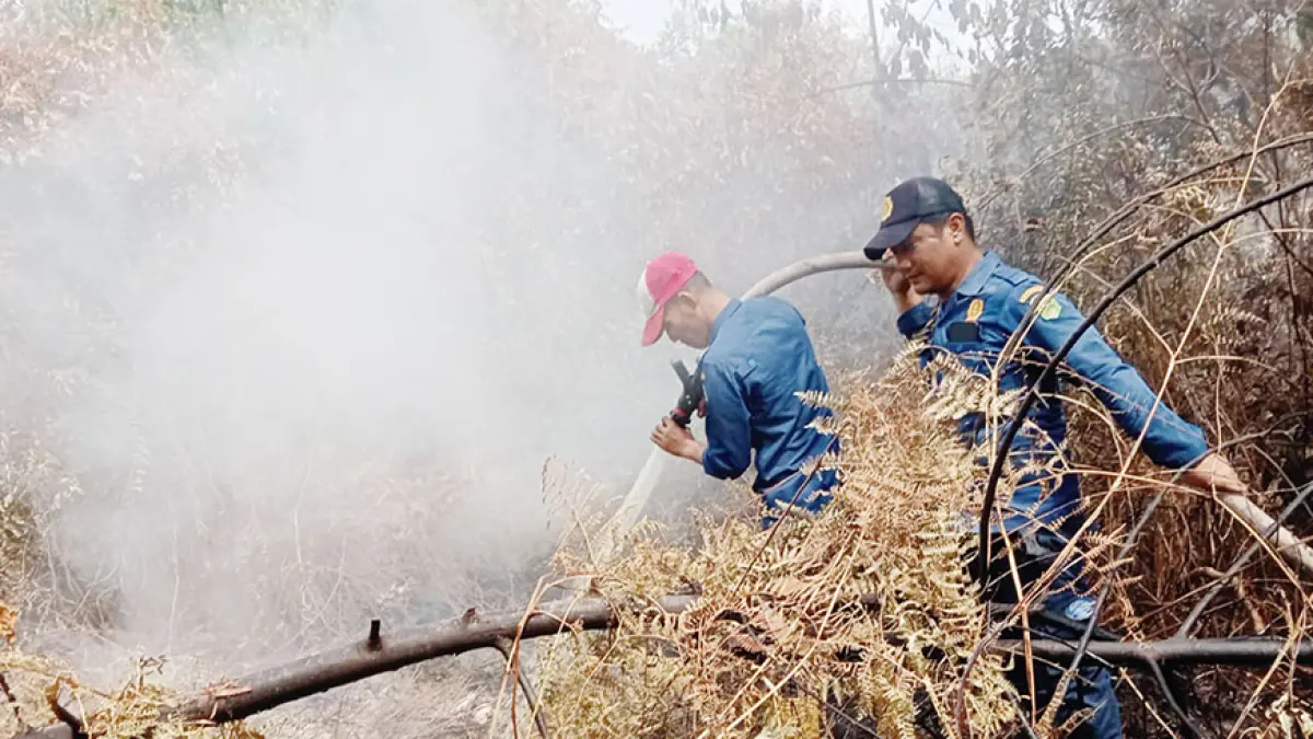 Tim BPBD Kecamatan Sungai Apit melakukan pendinginan terhadap lahan yang terbakar di Desa Bunsur, Kecamatan Sungai Apit, Kabupaten Siak, Senin (10/8/2026). (MONANG LUBIS/RIAU POS)