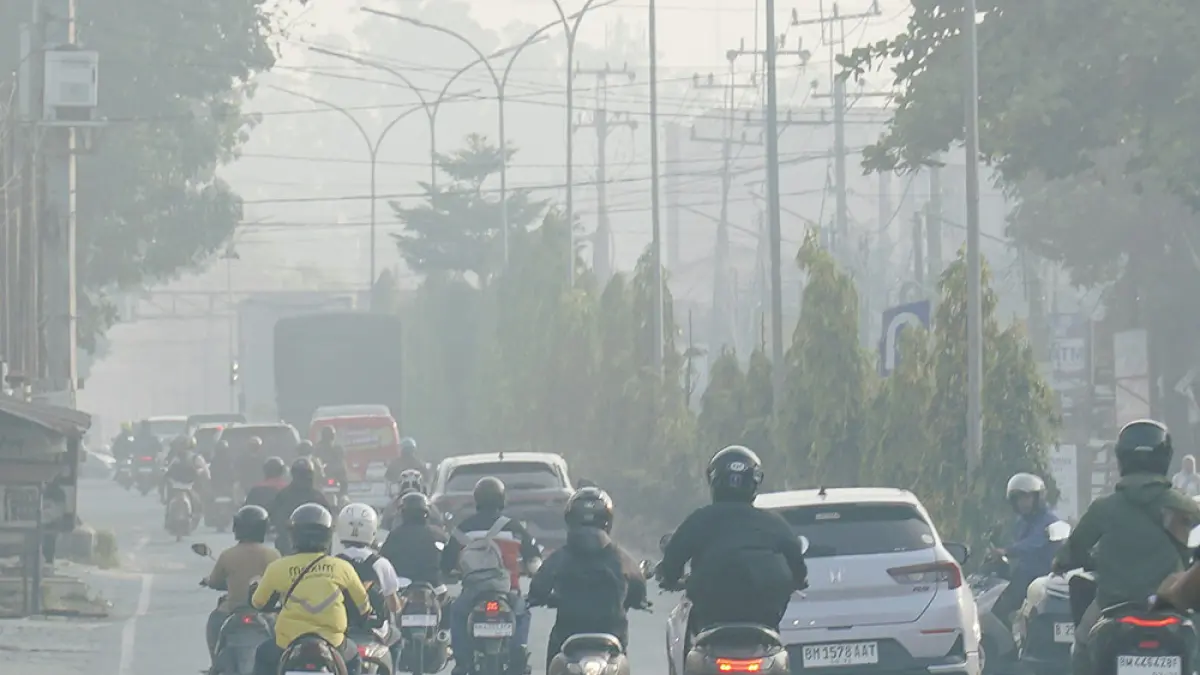 Kendaraan melintas di Jalan Kaharuddin Nasution, Pekanbaru yang diselimuti kabut asap, Rabu (12/8/2026) pagi.  (MHD AKHWAN/RIAU POS)