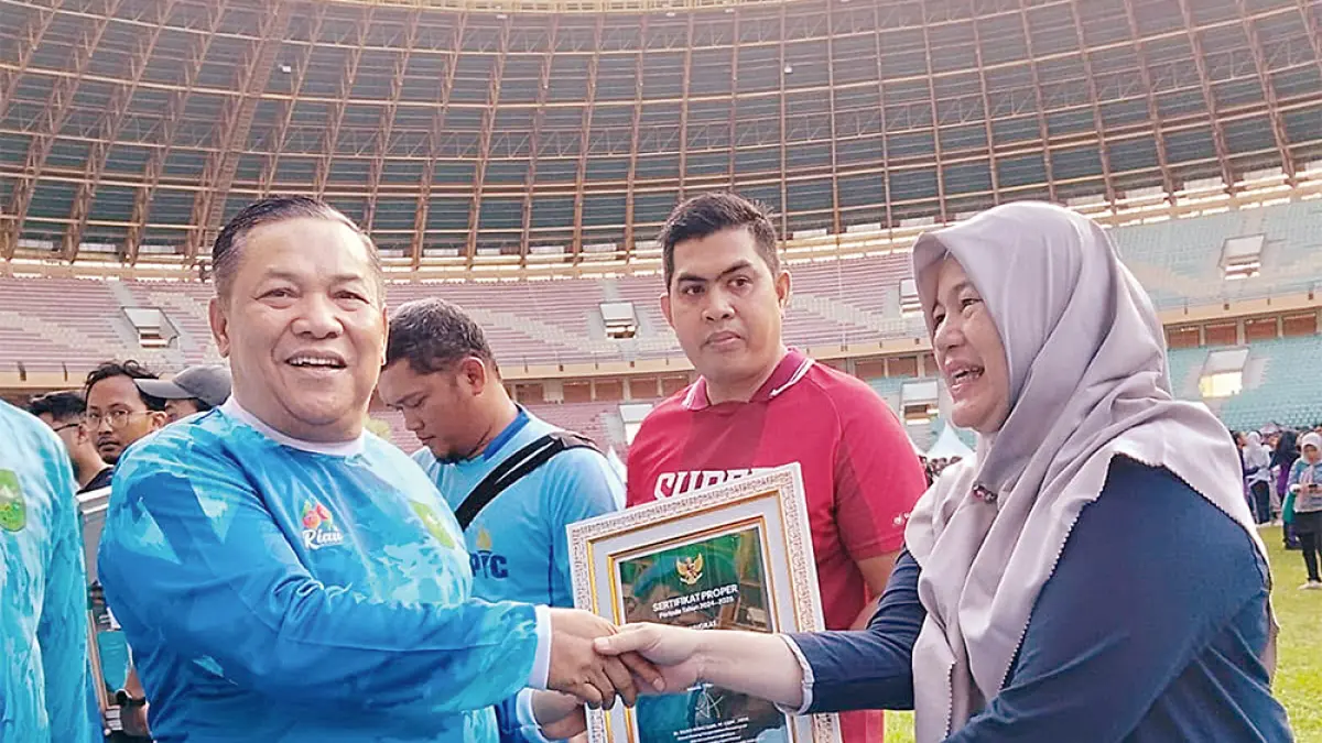 Plt Gubernur Riau SF Hariyanto menyerahkan penghargaan kepada perwakilan PTPN IV Regional III, Manajer Kebun dan PKS Sungai Pagar Triana Anggraini di Stadion Utama Riau, Pekanbaru, belum lama ini. (Humas PTPN IV Regional III&nbsp;untuk riau pos)