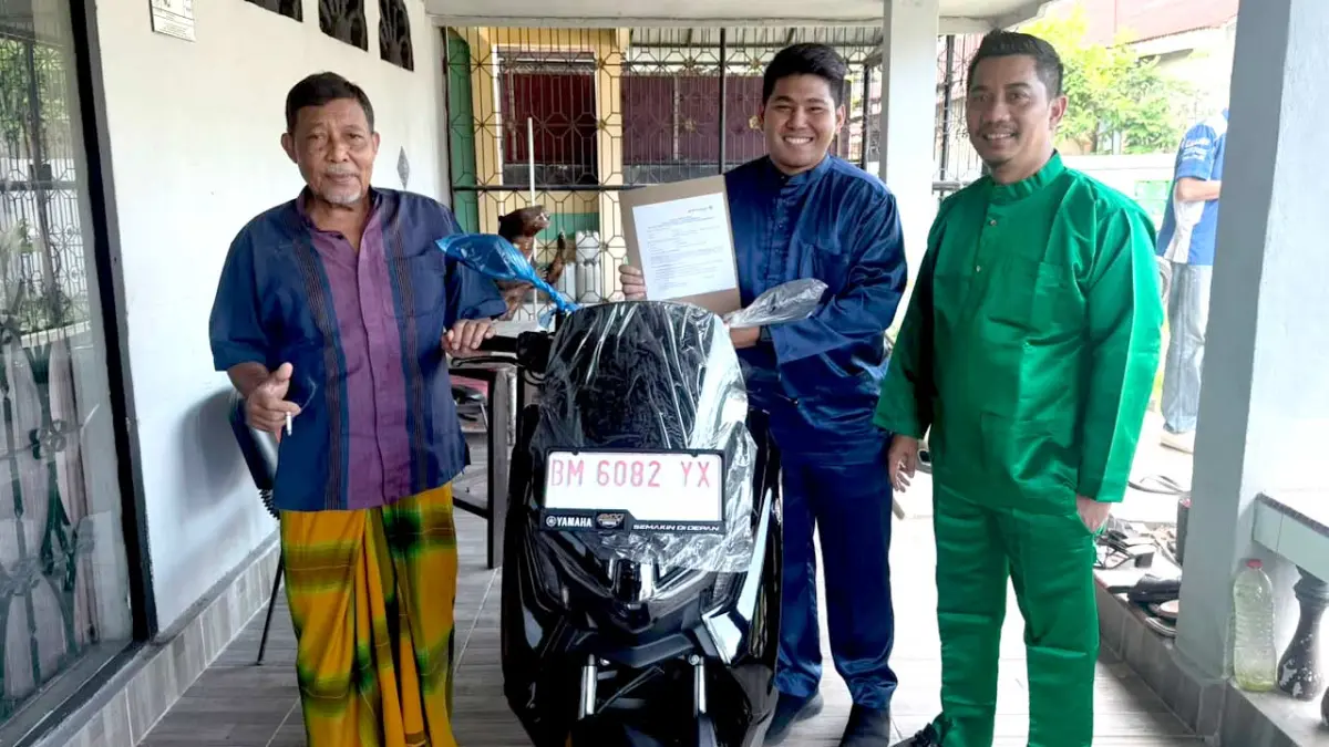 Syafaruddin (kiri) berhasil mendapatkan hadiah sepeda motor Yamaha Nmax dari Program Bedelau Bank Riau Kepri Syariah