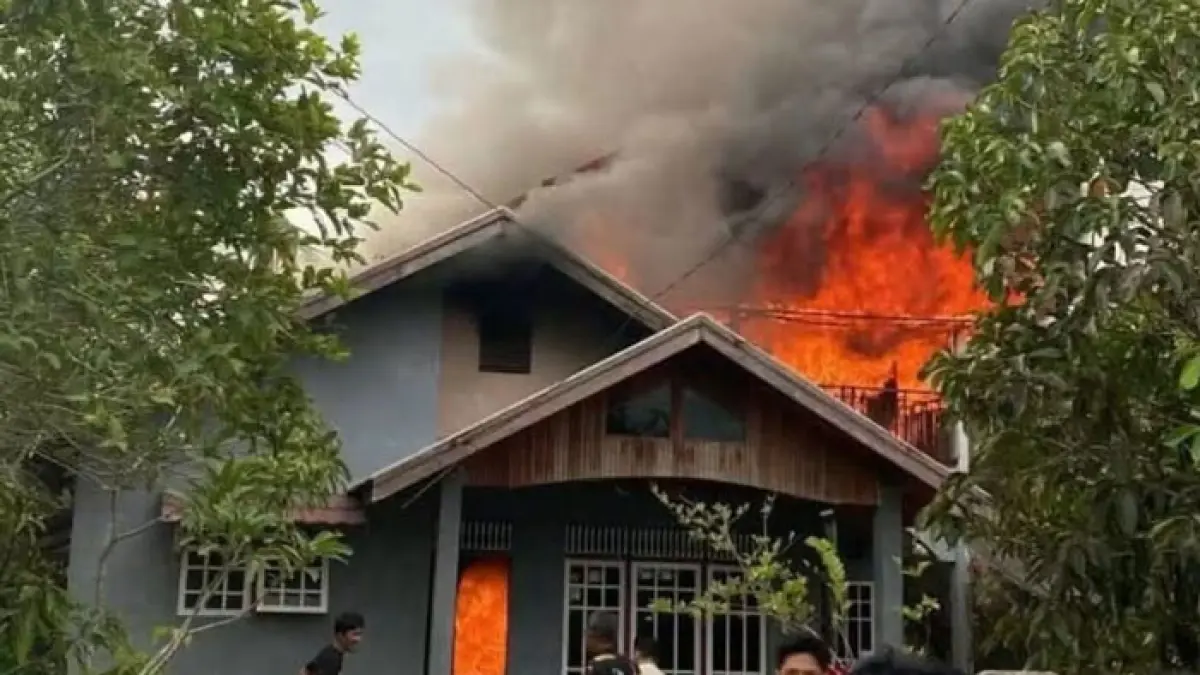 Warga berupaya menyelamatkan barang-barang dari rumah yang terbakar di Jalan Tanjung Harapan, Tembilahan, Kamis (13/8/2026). (Istimewa)