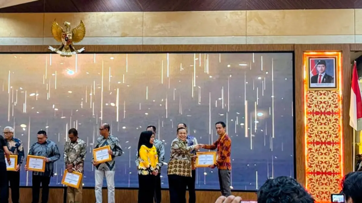 Pj Gubernur Riau SF Hariyanto memberikan penghargaan kepada Alfamart di Pekanbaru, Jumat (14/8/2026).(Istimewa)