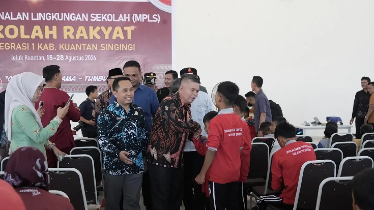 Pj Sekda Kuansing Drs Muradi MSi didampingi Kepala Sekolah Rakyat Zaidul Kamal menyalami siswa Sekolah Rakyat usai membuka masa pengenalan lingkungan sekolah (MPLS), Sabtu (15/8/2026). (Desriandi Candra/Riaupos.co)