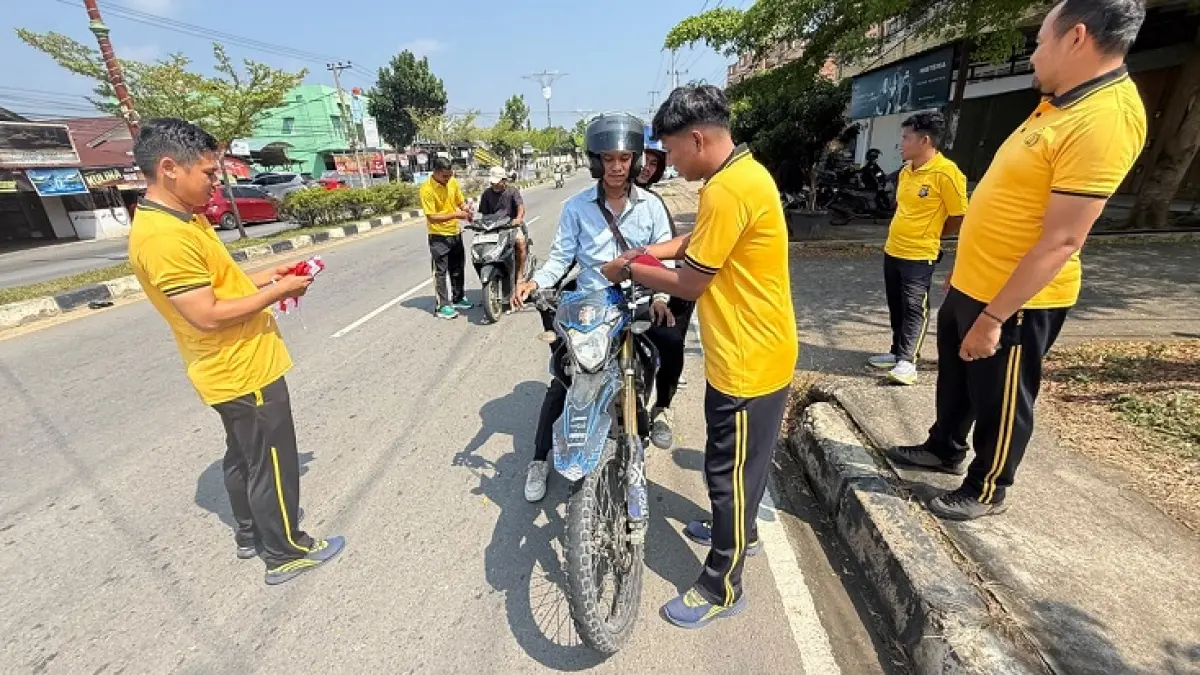 Sat Intelkam Polres Kuansing Bagi-bagi bendera di ruas jalan Teluk Kuantan, Sabtu (15/6/2026). (Istimewa)