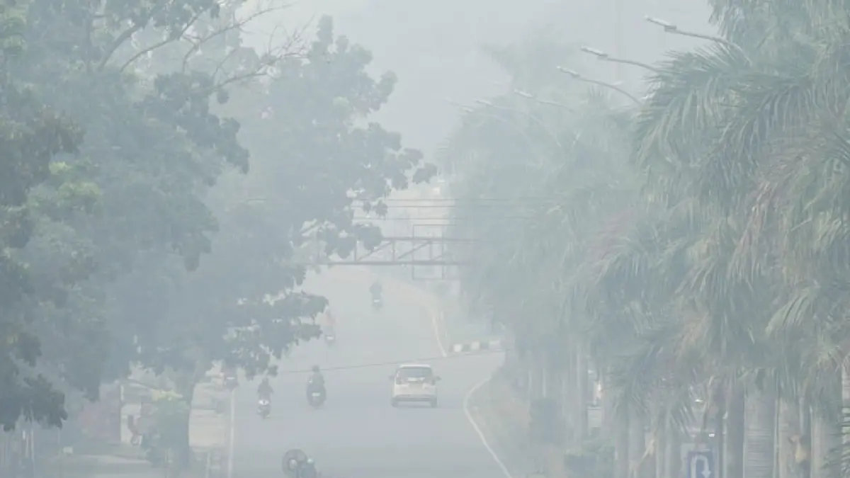 Kendaraan menembus Asap tebal dari Karhutla yang menyelimuti Kota Pekanbaru, Selasa (18/8/2026). (Mhd Akhwan/Riaupos.co)