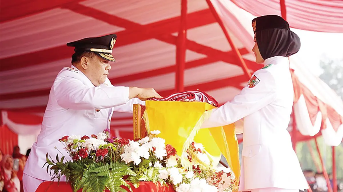 Pelaksana Tugas Gubernur Riau SF Hariyanto menyerahkan bendera yang akan dikibarkan pada upacara peringatan HUT ke-81 Kemerdekaan RI di Halaman Kantor Gubernur Riau, Senin (17/8/2026).(Diskominfotik Riau untuk Riau Pos)