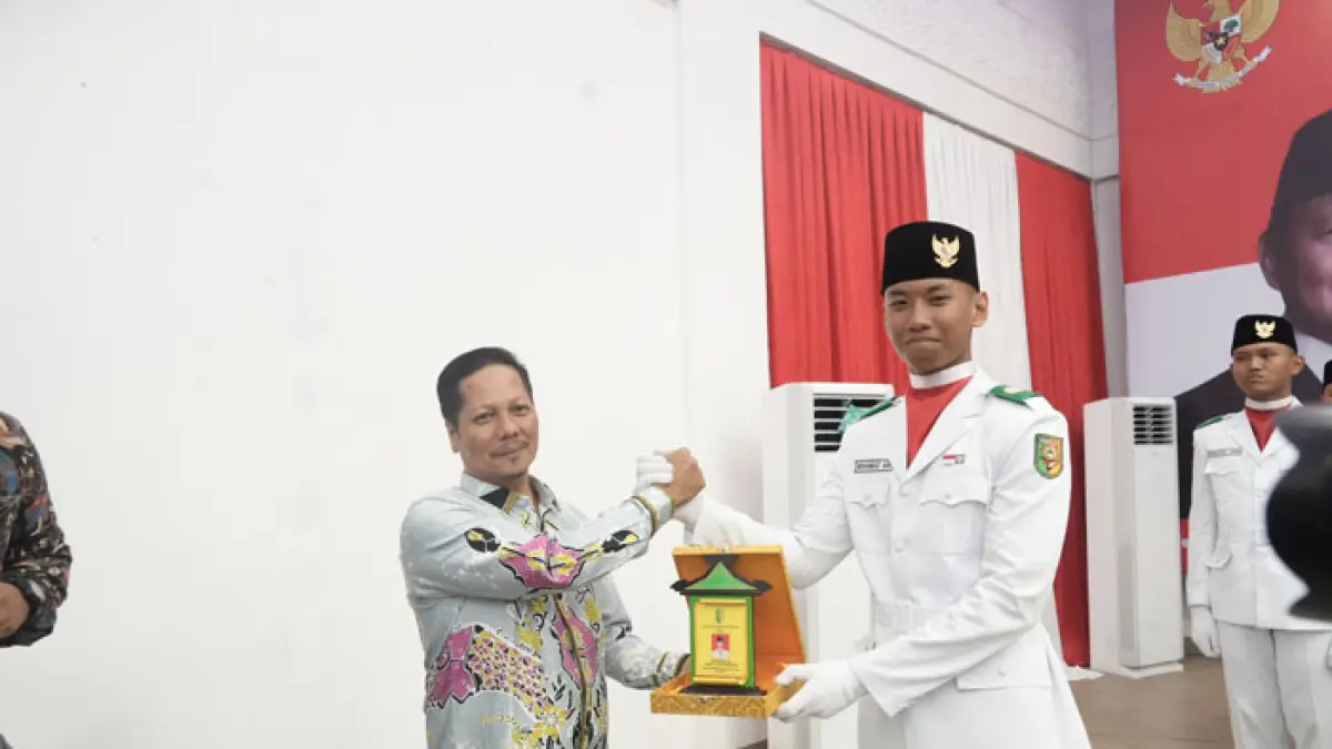 Plt Bupati Kuansing H Muklisin menyerahkan cenderamata pada perwakilan Paskibraka Kuansing ada malam resepsi, Senin (18/8/2026) di pendopo rumah dinas jabatan. (Istimewa)
